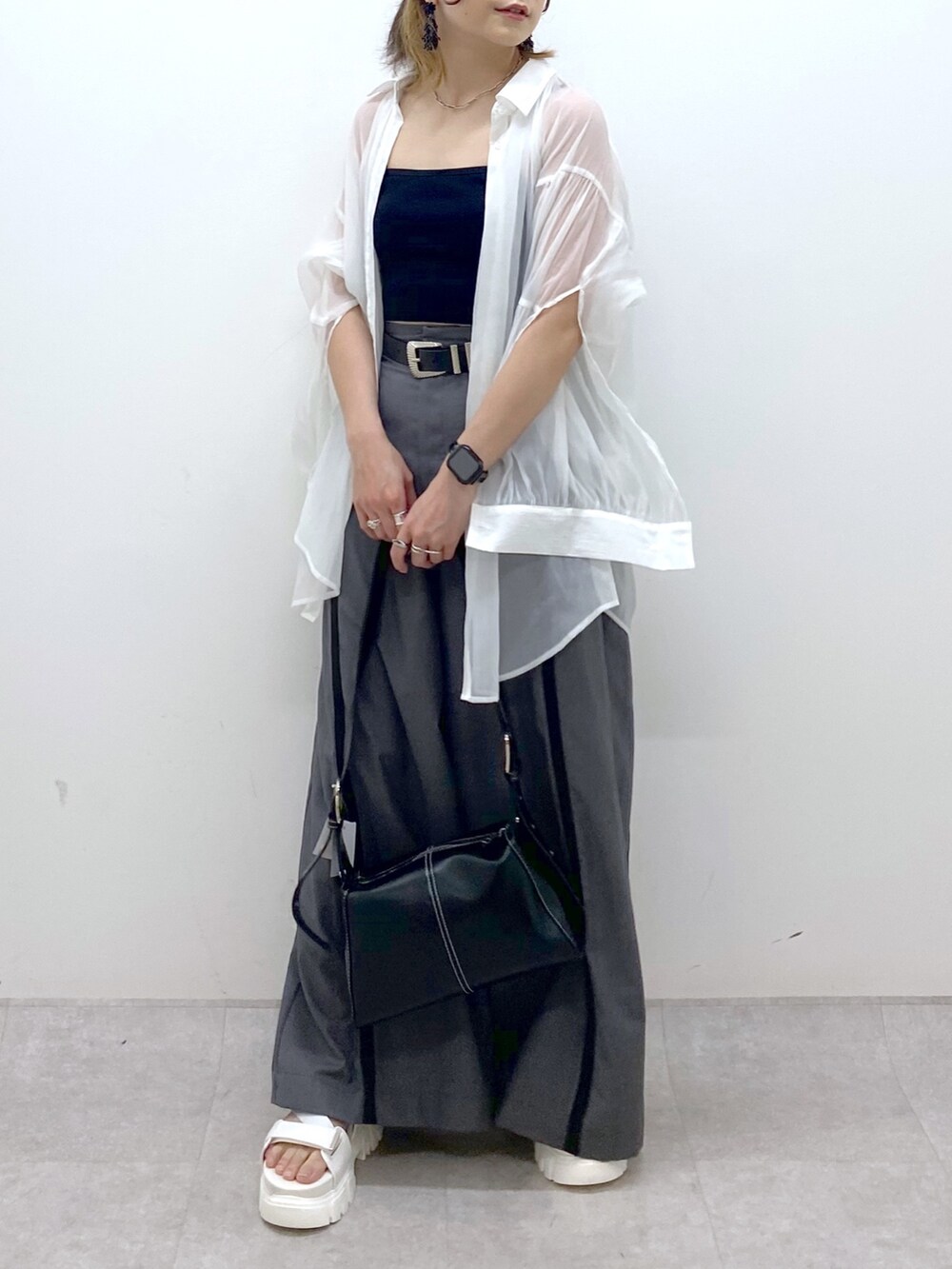 グレー系のスラックス、ブラック系のキャミソール、ブラック系のショルダーバッグを着用したレディースの夏コーディネートの7枚目の写真