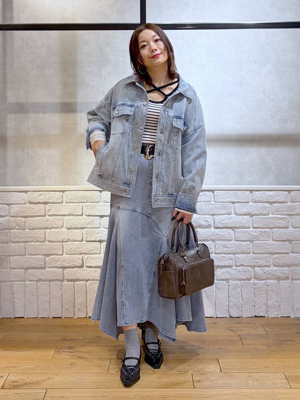 ブルー系のブルゾン、グレー系のショルダーバッグ、ホワイト系のニット/セーターを着用したレディースの春コーディネートの9枚目の写真