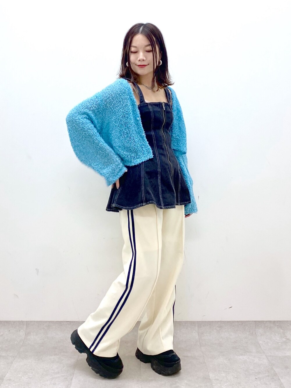 ホワイト系のその他パンツ、ブラック系のスニーカー、ブルー系のカーディガン/ボレロを着用したレディースの春コーディネートの4枚目の写真