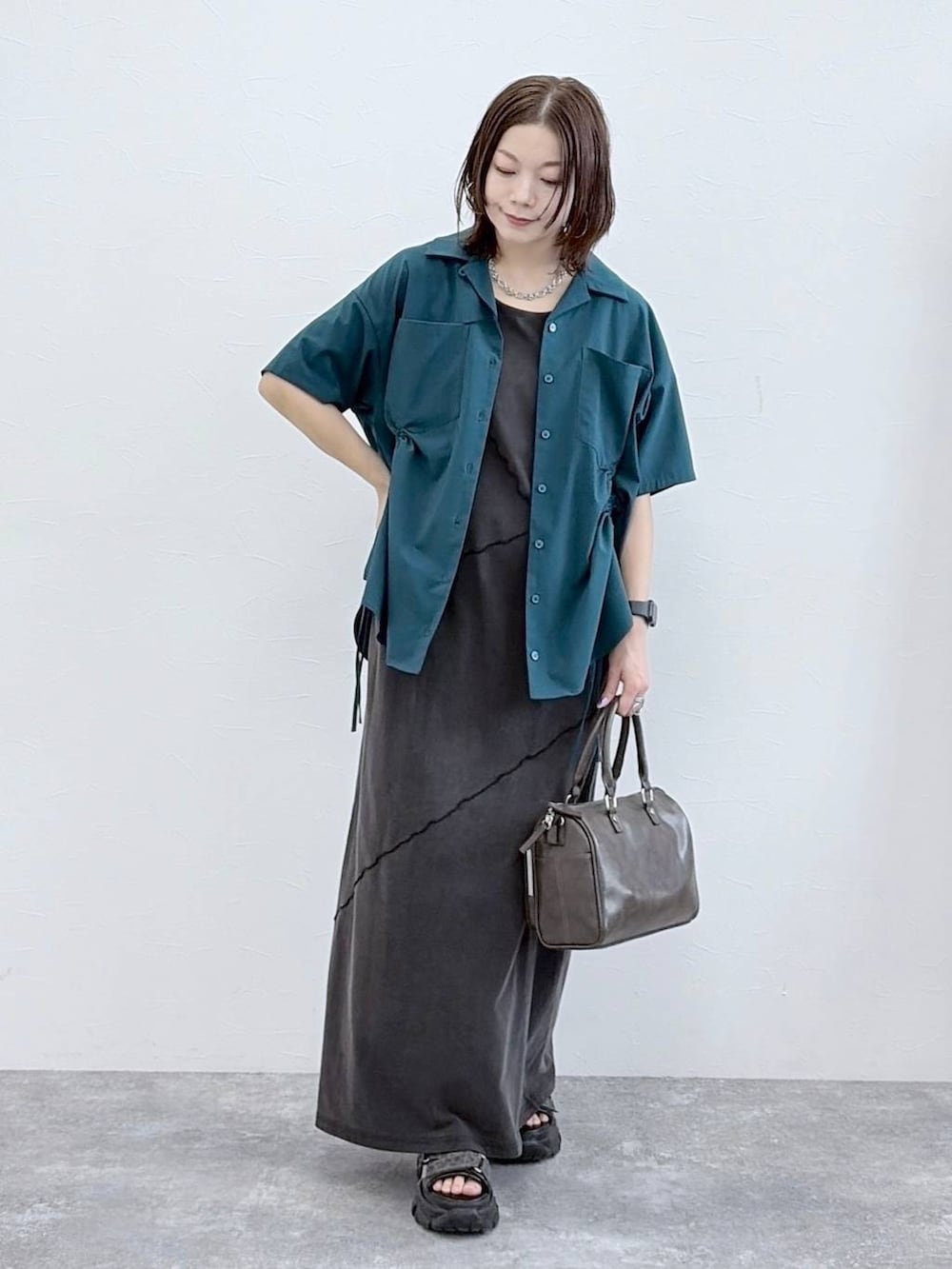 ブラック系のワンピース、グレー系のショルダーバッグ、グリーン系のシャツ/ブラウスを着用したレディースの春コーディネートの4枚目の写真