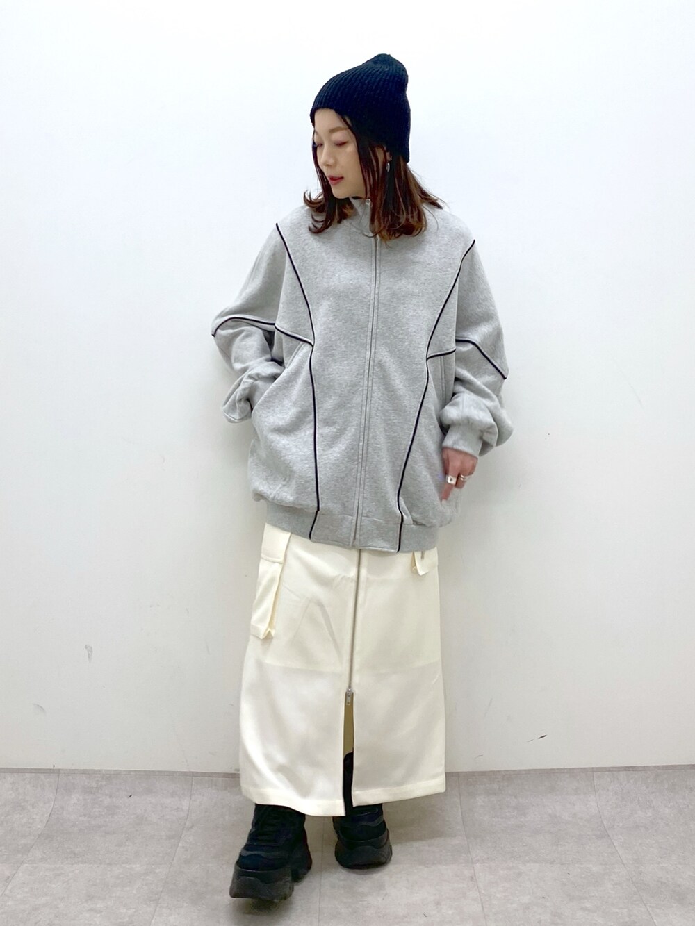 ホワイト系のスカート、ブラック系のスニーカー、グレー系のスウェットを着用したレディースの冬コーディネートの9枚目の写真