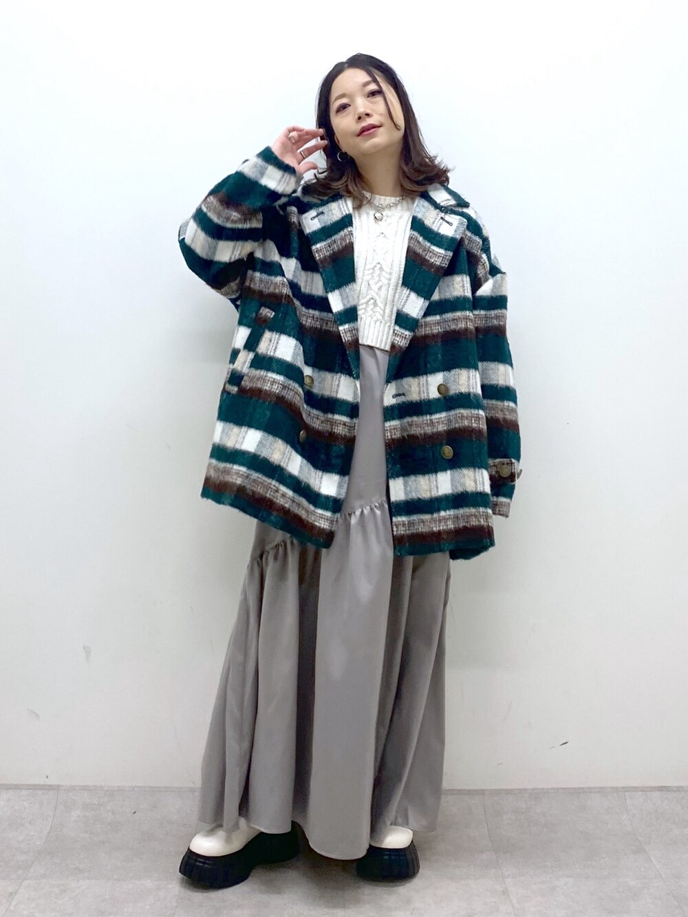 グリーン系のその他アウター、ホワイト系のニット/セーター、ホワイト系のワンピースを着用したレディースの冬コーディネートの2枚目の写真