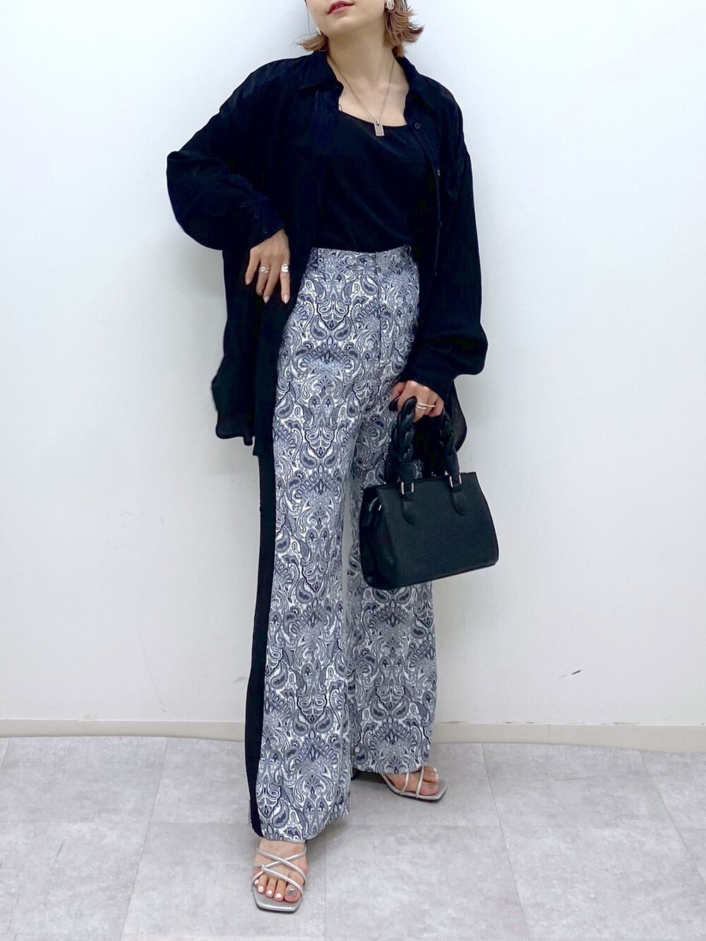 ブラック系のトップス、ホワイト系のその他パンツ、シルバー系のサンダルを着用したレディースの夏コーディネートの5枚目の写真