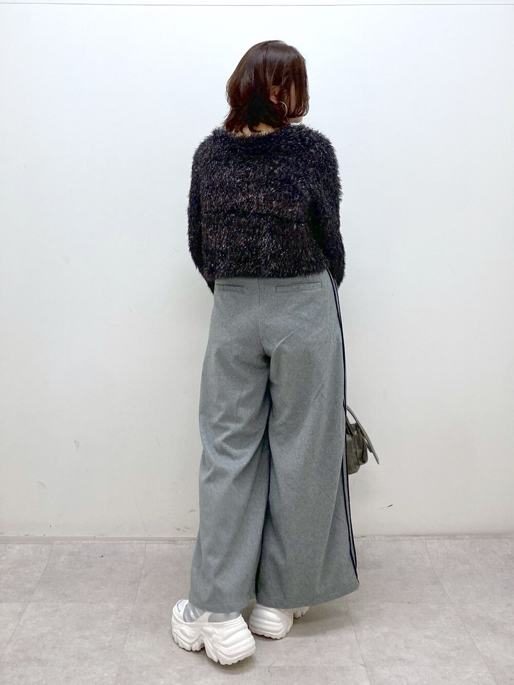 ブラック系のニット/セーター、ブラック系のスラックス、その他のショルダーバッグを着用したレディースの冬コーディネートの6枚目の写真