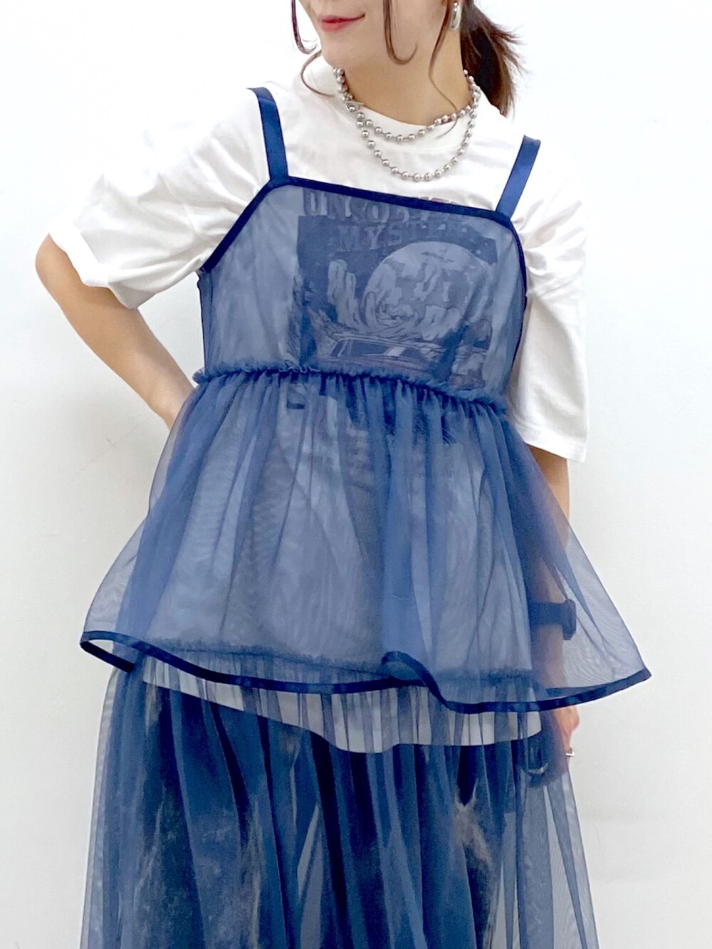 ホワイト系のTシャツ/カットソー、ブルー系のワンピース、ブラック系のデニムパンツを着用したレディースの春コーディネートの2枚目の写真