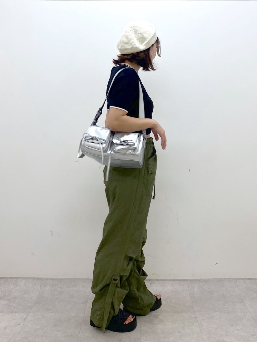 グリーン系のカーゴパンツ、ブラック系のサンダル、シルバー系のショルダーバッグを着用したレディースの夏コーディネートの7枚目の写真