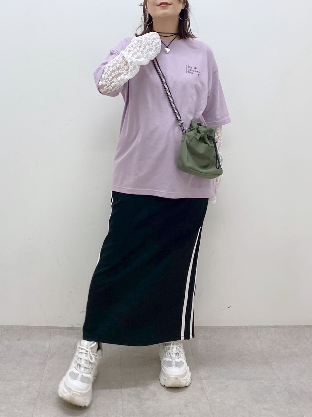 ブラック系のスカート、ホワイト系のスニーカー、ホワイト系のTシャツ/カットソーを着用したレディースの夏コーディネートの3枚目の写真