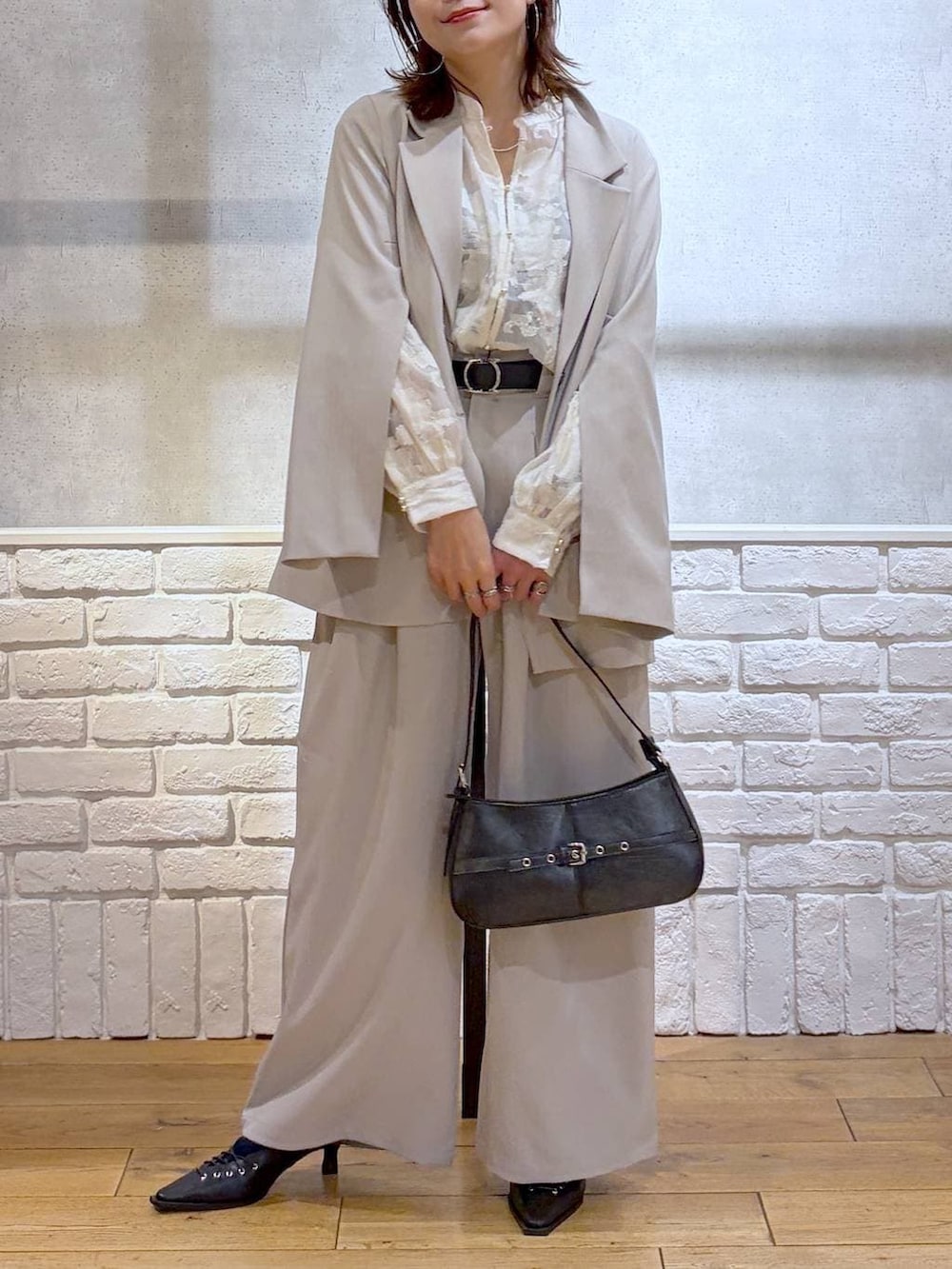 グレー系のテーラードジャケット、ベージュ系のデニムパンツ、ホワイト系のTシャツ/カットソーを着用したレディースの冬コーディネートの2枚目の写真