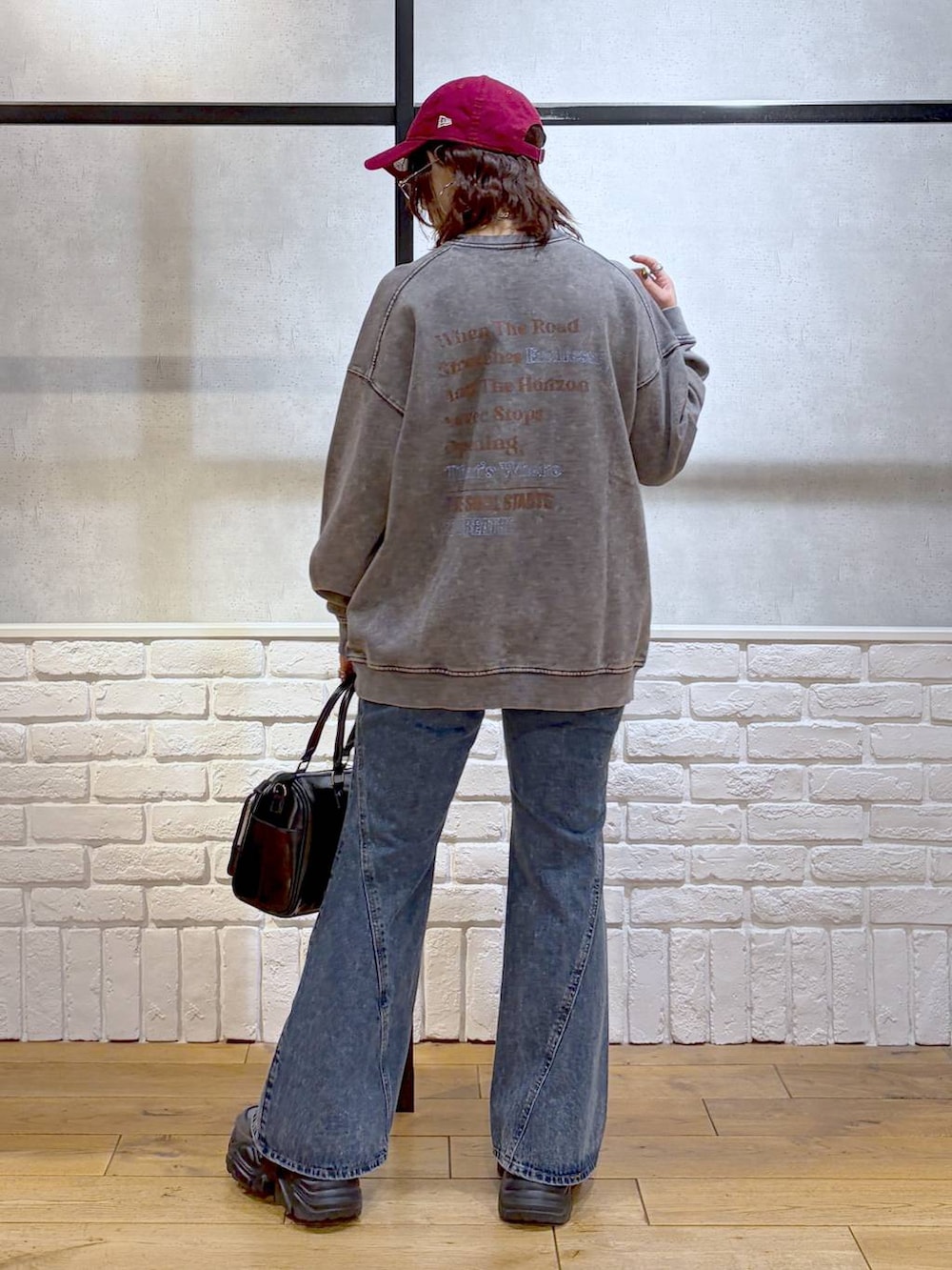 グレー系のスニーカー、ブルー系のデニムパンツ、ブラック系のショルダーバッグを着用したレディースの冬コーディネートの6枚目の写真