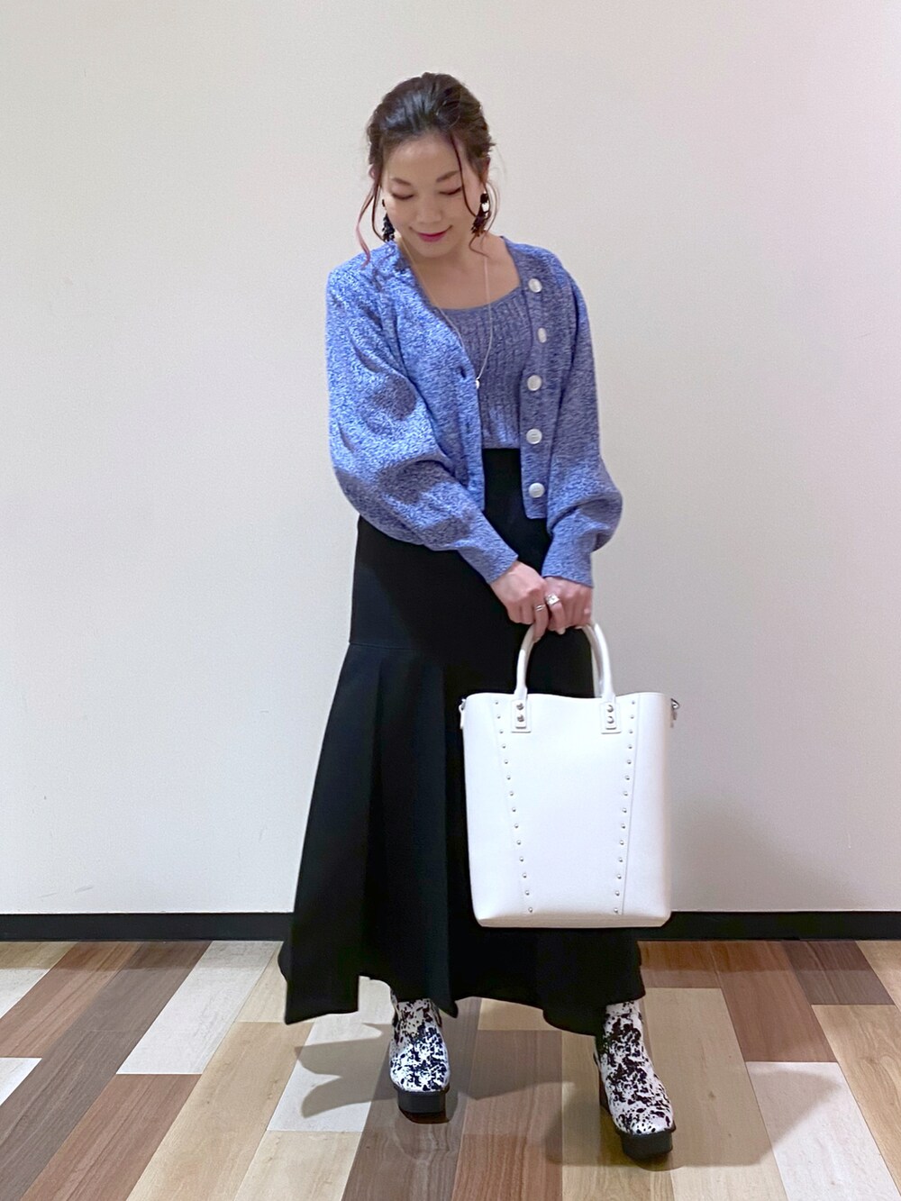 ブラック系のスカート、ホワイト系のブーツ、ホワイト系のショルダーバッグを着用したレディースの冬コーディネートの2枚目の写真