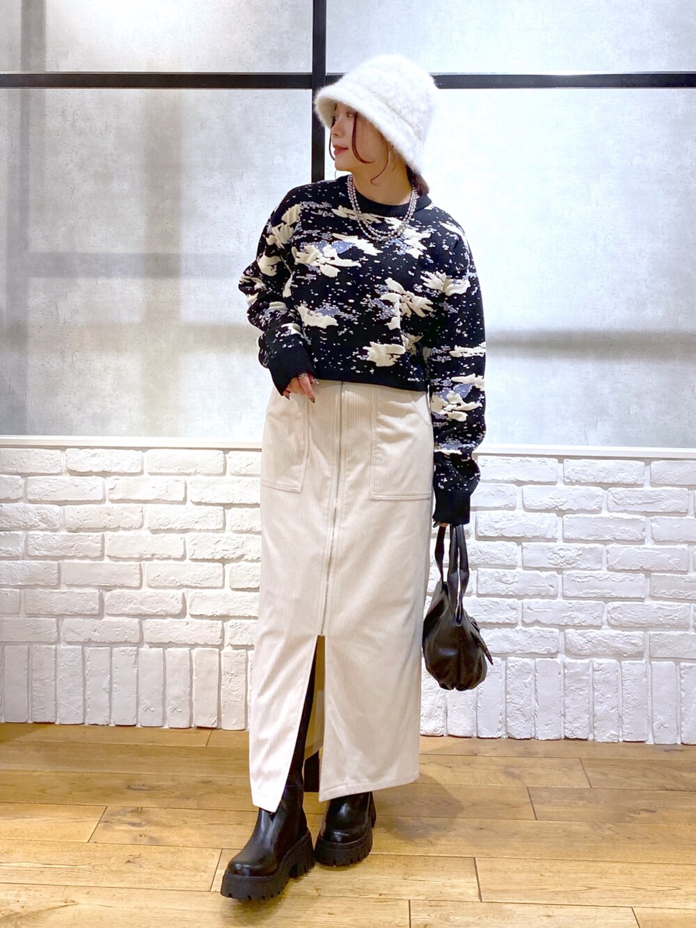 ブラック系のニット/セーター、ブラック系のハンドバッグ、ブラック系のブーツを着用したレディースの冬コーディネートの9枚目の写真