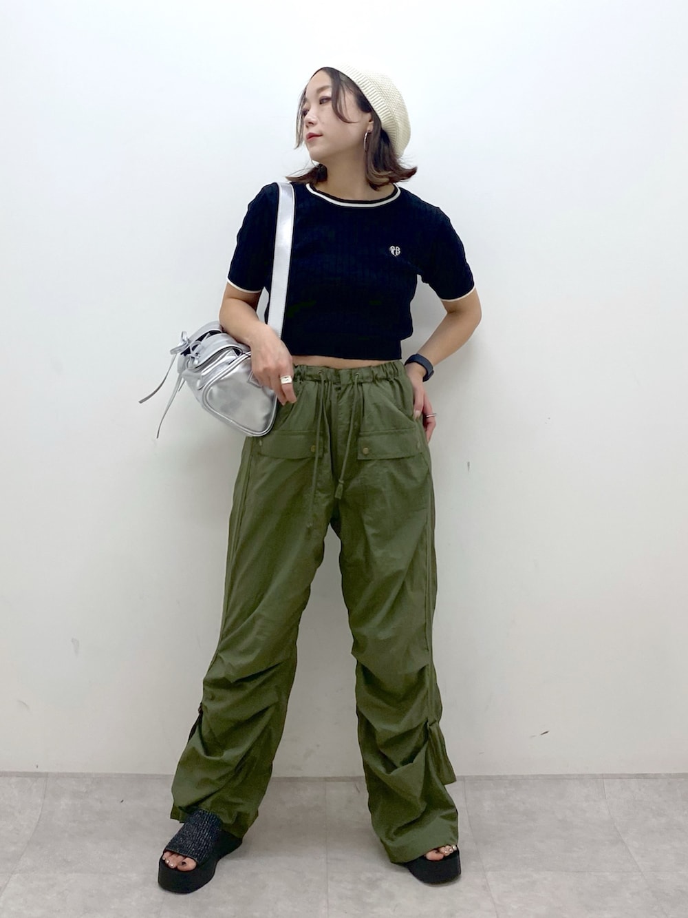 グリーン系のカーゴパンツ、ブラック系のサンダル、シルバー系のショルダーバッグを着用したレディースの夏コーディネートの9枚目の写真