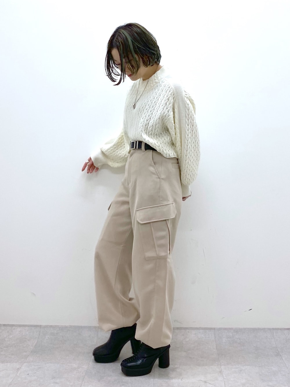 ベージュ系のカーゴパンツ、ホワイト系のニット/セーター、ブラック系のブーツを着用したレディースの冬コーディネートの3枚目の写真