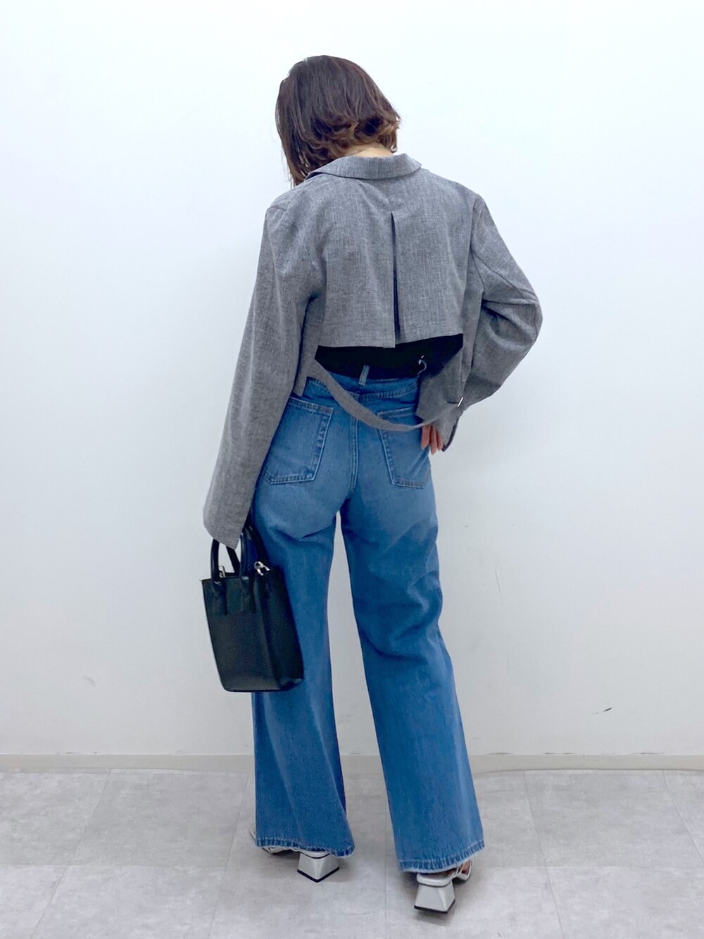 ブルー系のパンツ、グレー系のテーラードジャケット、シルバー系のサンダルを着用したレディースの夏コーディネートの4枚目の写真