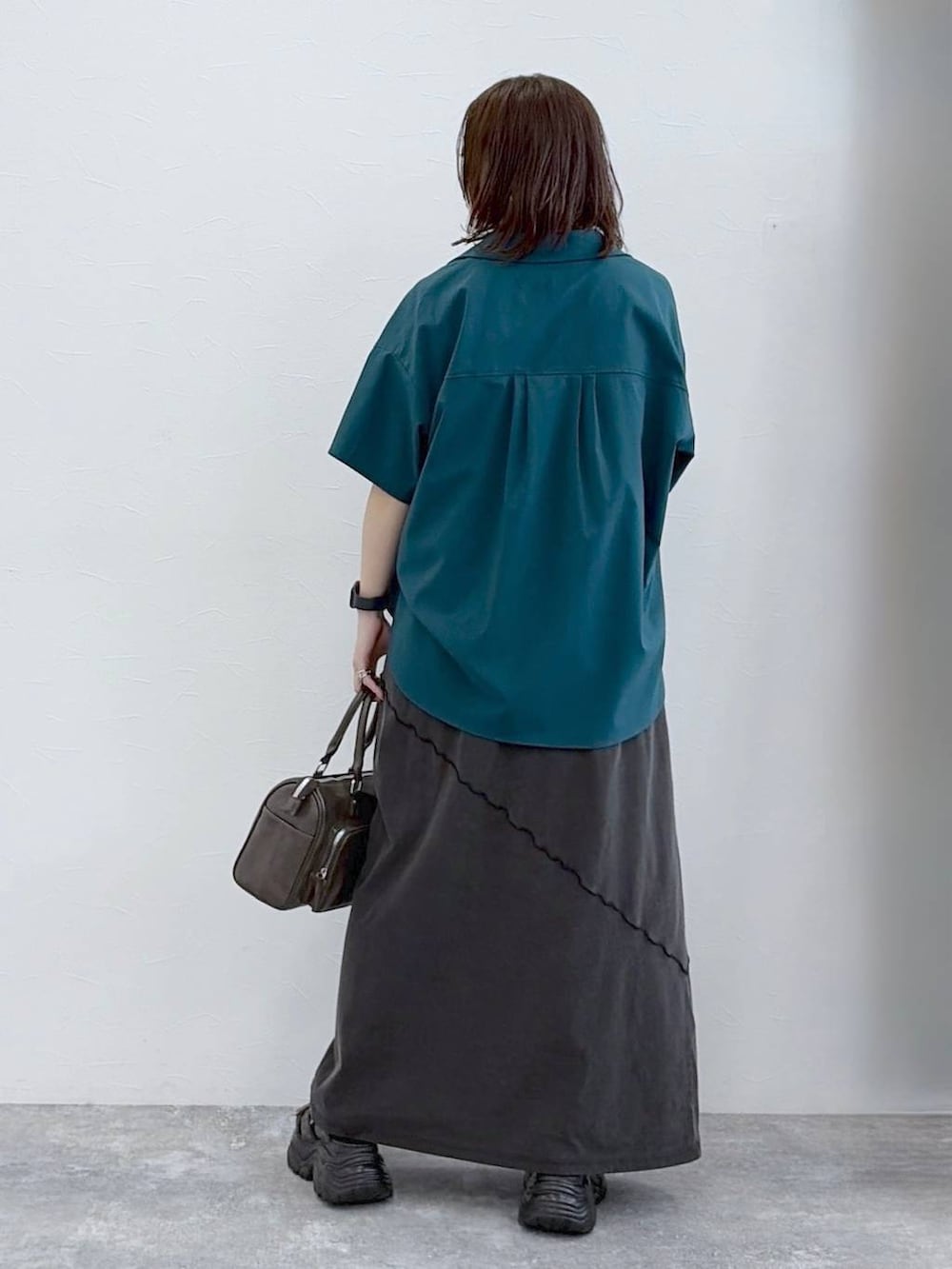 ブラック系のワンピース、グレー系のショルダーバッグ、グリーン系のシャツ/ブラウスを着用したレディースの春コーディネートの6枚目の写真