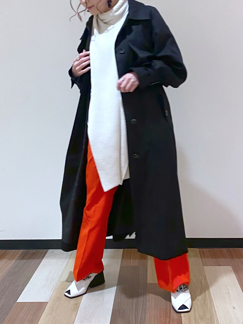 ブラック系のトレンチコート、レッド系のスラックス、ホワイト系のパンプスを着用したレディースの冬コーディネートの4枚目の写真