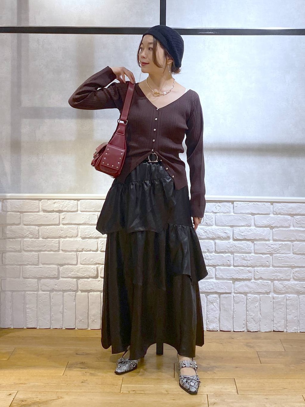ホワイト系のパンプス、レッド系のショルダーバッグ、ブラック系のスカートを着用したレディースの夏コーディネートの4枚目の写真