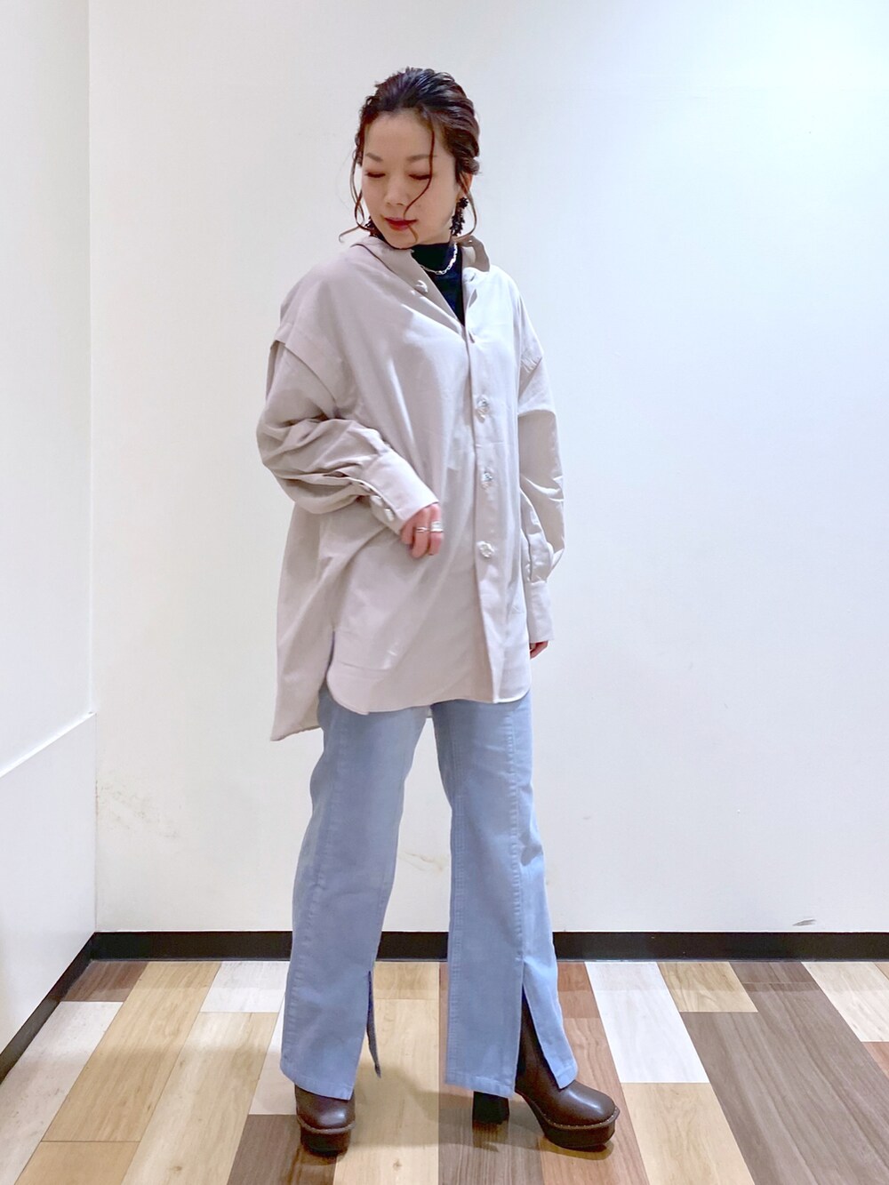 ベージュ系のシャツ/ブラウス、ブラック系のニット/セーター、ブルー系のその他パンツを着用したレディースの冬コーディネートの3枚目の写真