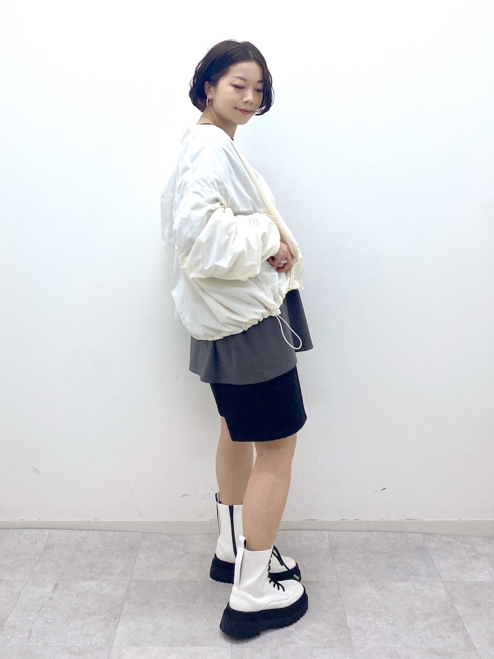 グレー系のTシャツ/カットソー、ブラック系のパンツ、ホワイト系のジャケット/アウターを着用したレディースの秋コーディネートの2枚目の写真