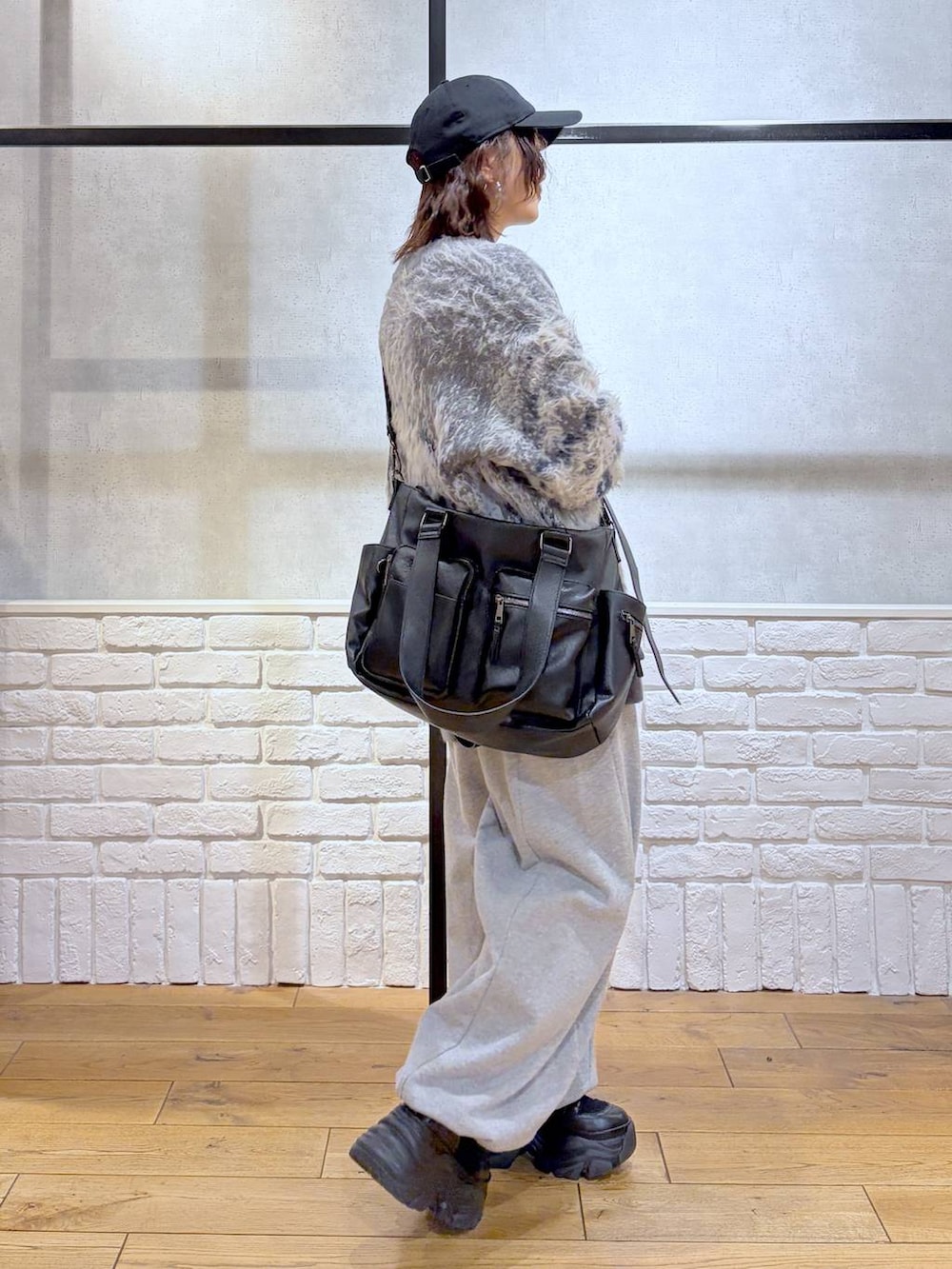 ブラック系のブーツ、グレー系のスウェットパンツ、ブラック系のボストンバッグを着用したレディースの冬コーディネートの7枚目の写真