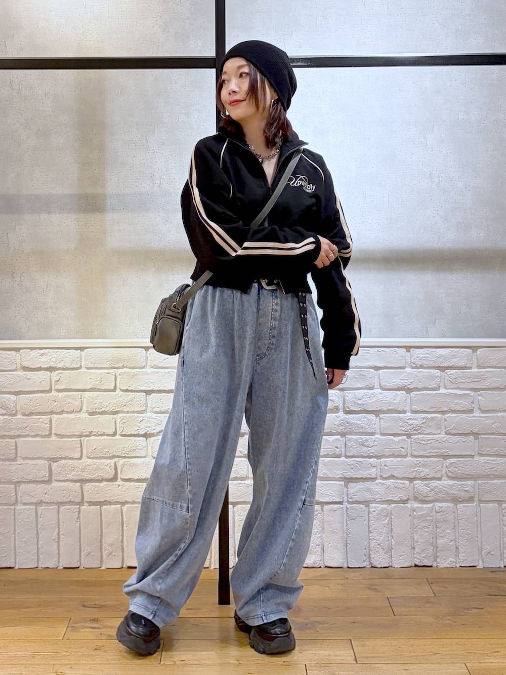 ブラック系のスニーカー、グレー系のショルダーバッグ、ブルー系のデニムパンツを着用したレディースの春コーディネートの8枚目の写真