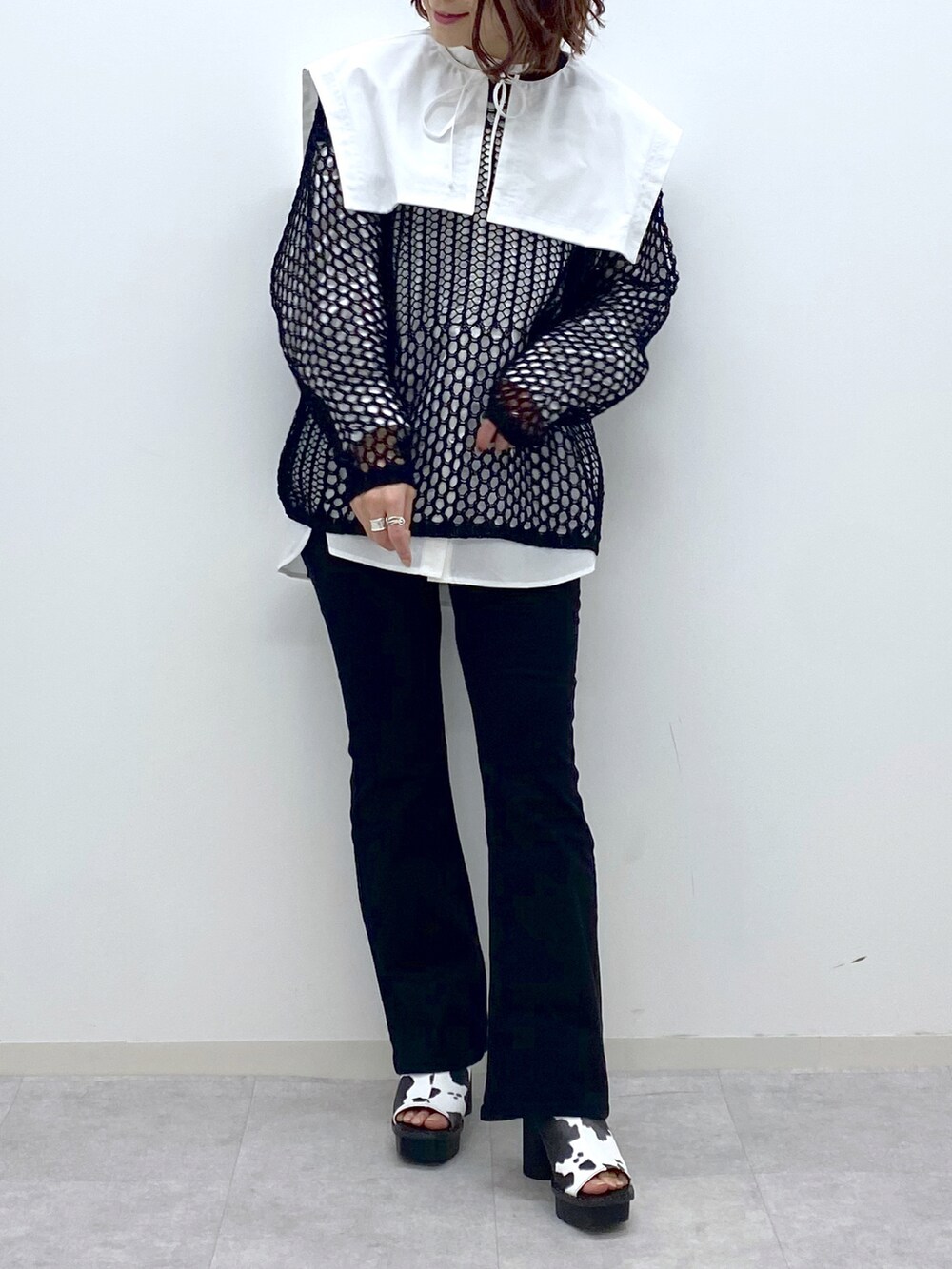 ブラック系のデニムパンツ、ホワイト系のサンダル、ホワイト系のシャツ/ブラウスを着用したレディースの春コーディネートの5枚目の写真