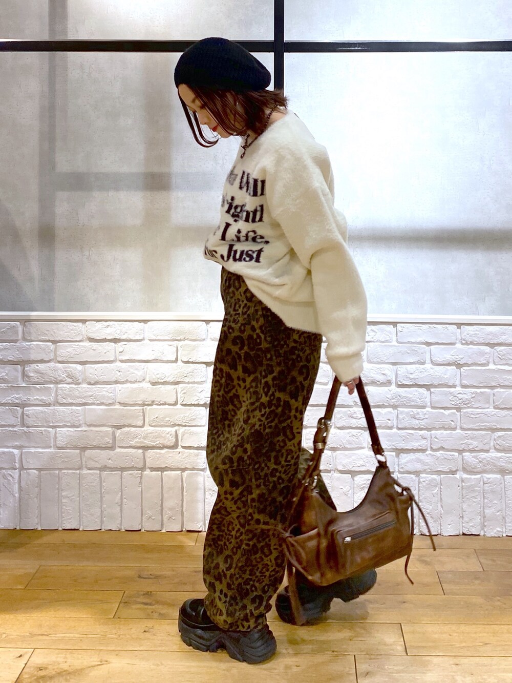 その他のデニムパンツ、ブラウン系のショルダーバッグ、ホワイト系のニット/セーターを着用したレディースの冬コーディネートの7枚目の写真