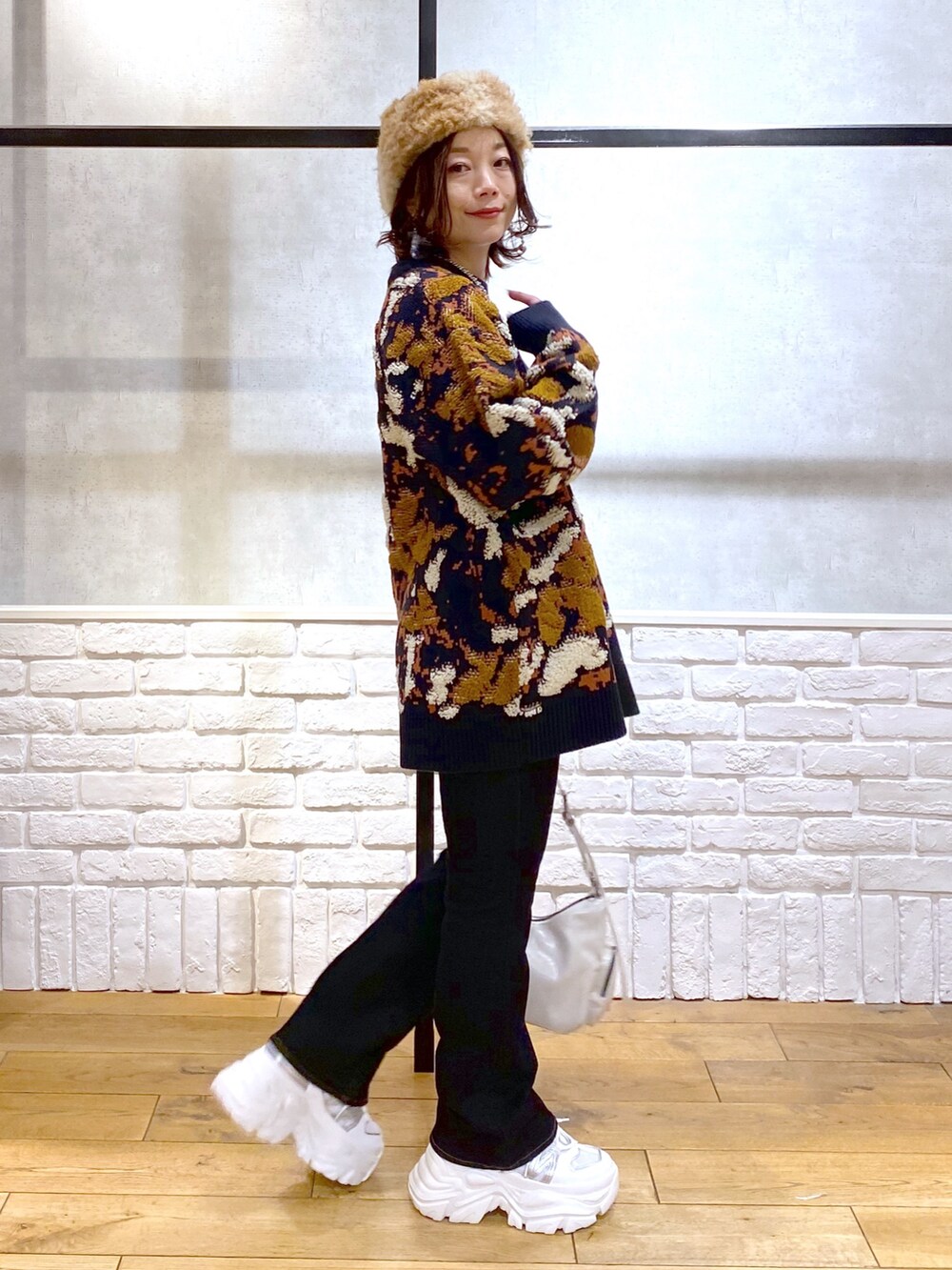 ブルー系のニット/セーター、ブルー系のデニムパンツ、ホワイト系のショルダーバッグを着用したレディースの冬コーディネートの5枚目の写真