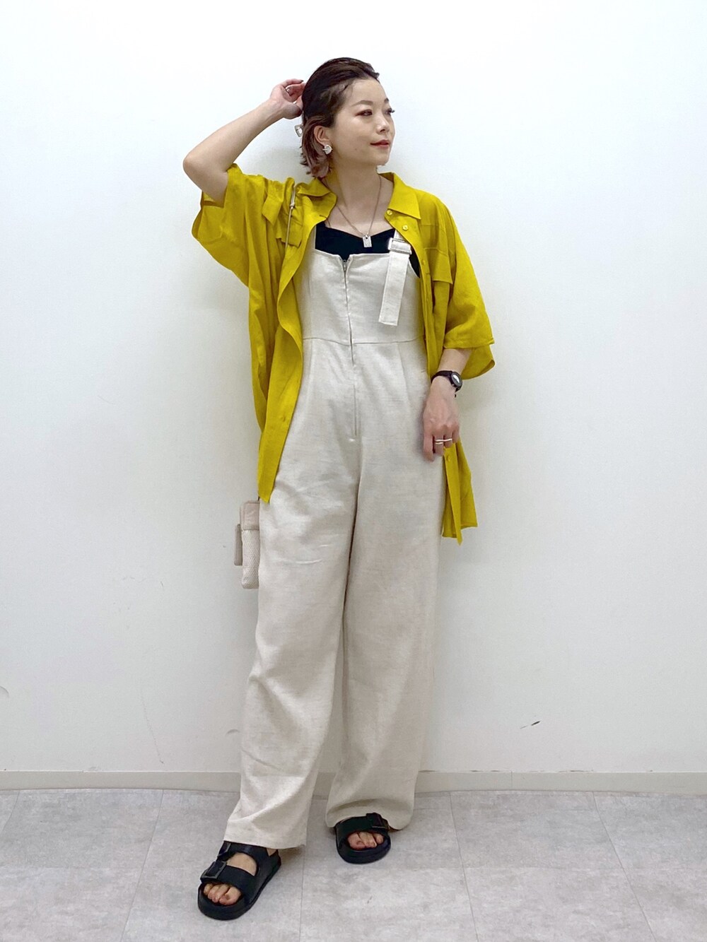 イエロー系のシャツ/ブラウス、ブラック系のサンダル、ブラック系のタンクトップを着用したレディースの夏コーディネートの2枚目の写真