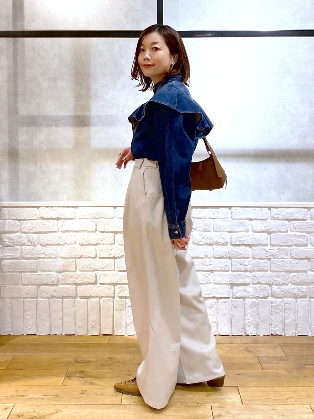 ブルー系のシャツ/ブラウス、ベージュ系のショルダーバッグ、ベージュ系のスラックスを着用したレディースの春コーディネートの7枚目の写真