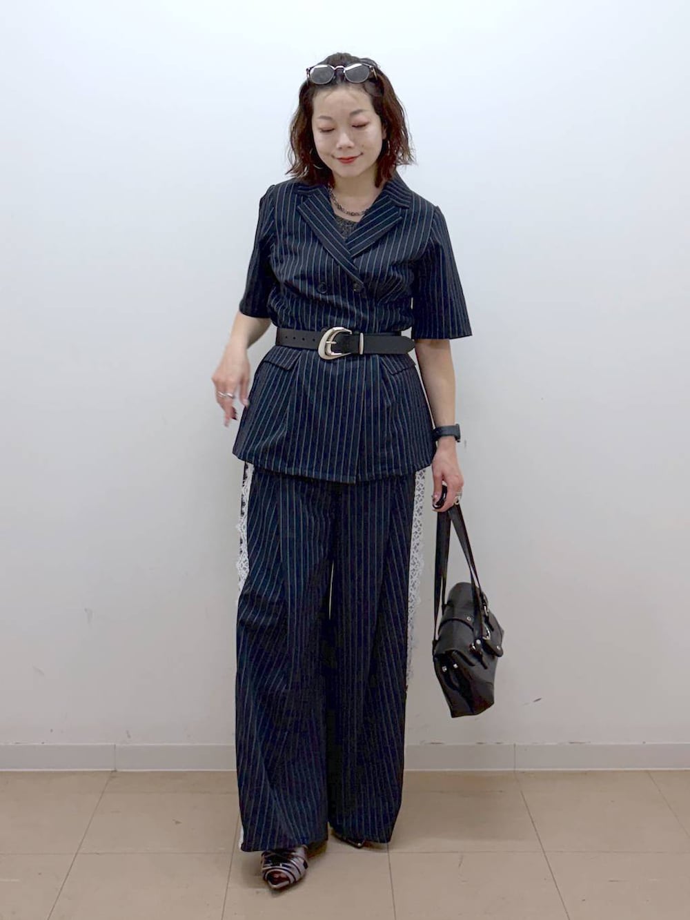 その他のサンダル、ブルー系のスラックス、グレー系のタンクトップを着用したレディースの夏コーディネートの9枚目の写真