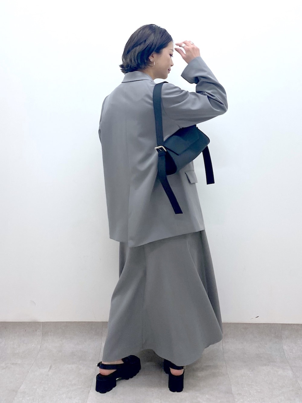 グレー系のジャケット/アウター、グレー系のスカート、ホワイト系のトップスを着用したレディースの春コーディネートの3枚目の写真