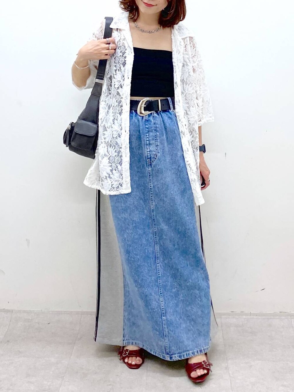 ブラック系のショルダーバッグ、レッド系のサンダル、ブルー系のスカートを着用したレディースの夏コーディネートの3枚目の写真