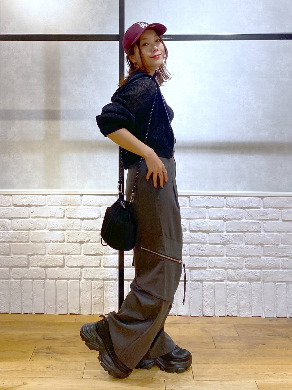 ブラック系のスニーカー、グレー系のカーゴパンツ、ブラック系のタンクトップを着用したレディースの夏コーディネートの7枚目の写真