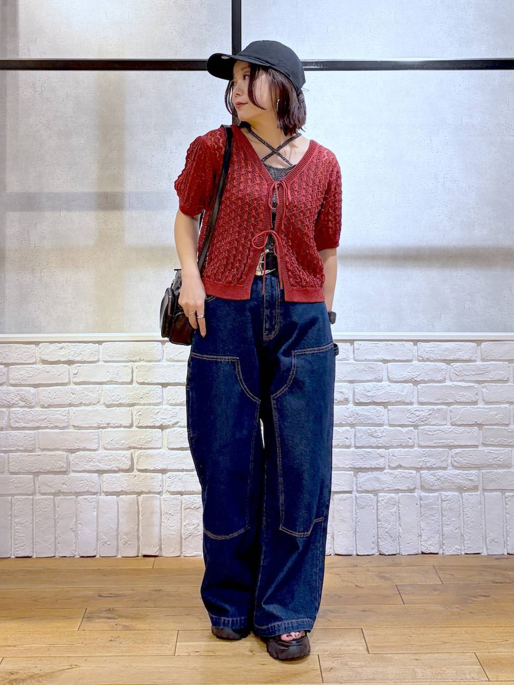 ブルー系のデニムパンツ、ブラック系のショルダーバッグ、ブラック系のサンダルを着用したレディースの夏コーディネートの4枚目の写真