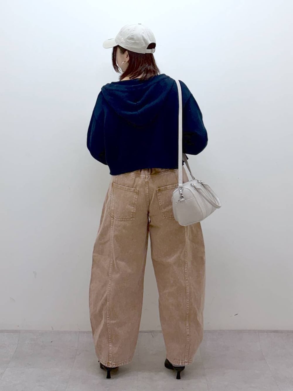 ブラウン系のデニムパンツ、ブラウン系のデニムパンツ、ホワイト系のボストンバッグを着用したレディースの冬コーディネートの6枚目の写真