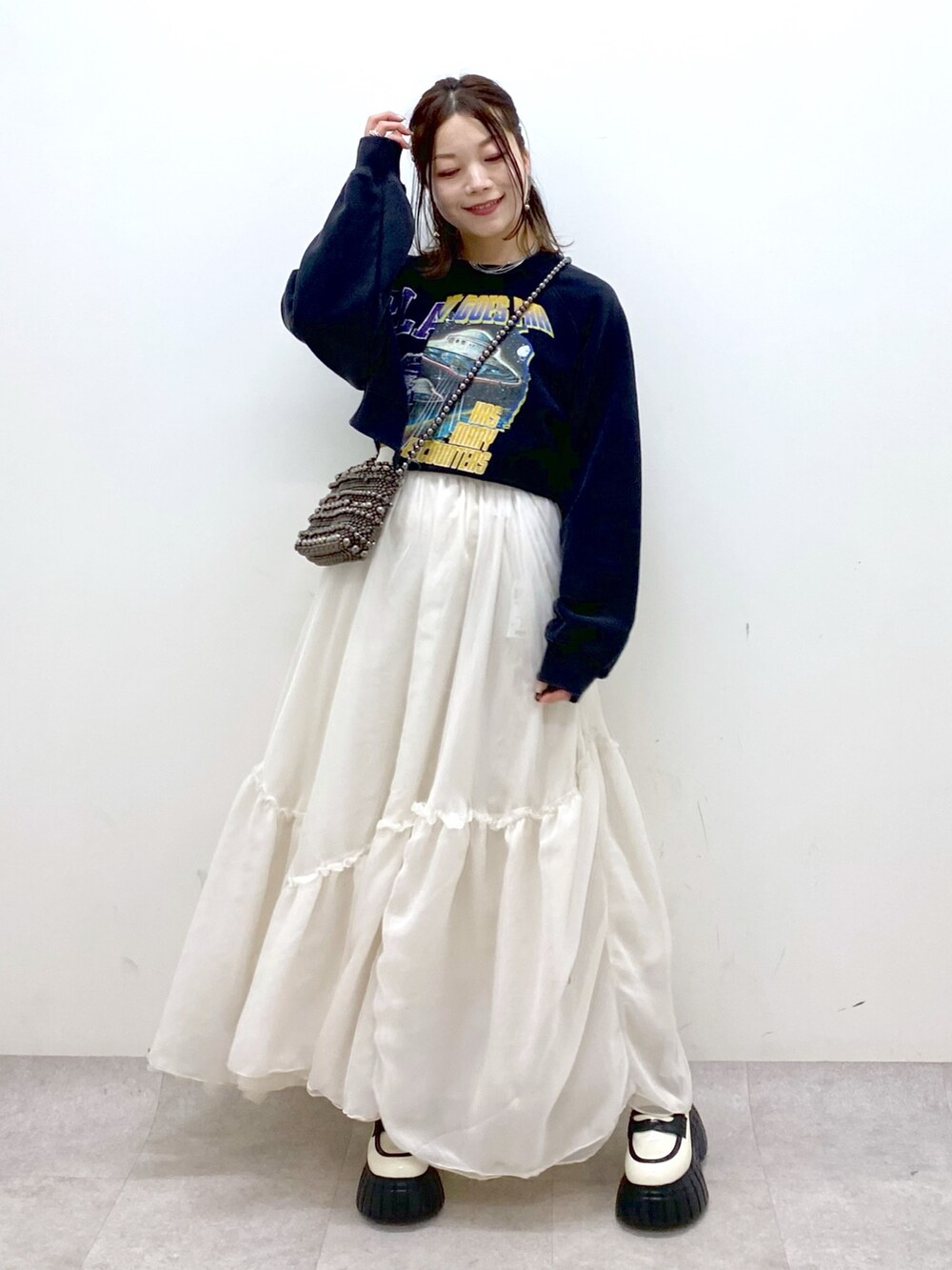 ブラック系のスウェット、ブラック系のショルダーバッグ、ホワイト系のスカートを着用したレディースの冬コーディネートの8枚目の写真