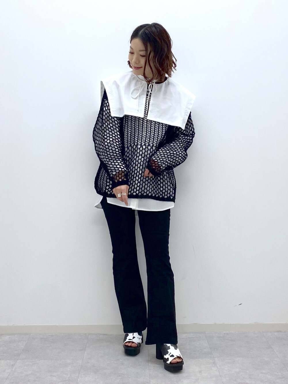 ブラック系のデニムパンツ、ホワイト系のサンダル、ホワイト系のシャツ/ブラウスを着用したレディースの春コーディネートの2枚目の写真