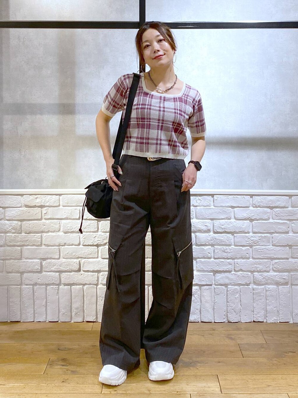 グレー系のカーゴパンツ、ブラック系のショルダーバッグ、ホワイト系のスニーカーを着用したレディースの夏コーディネートの9枚目の写真