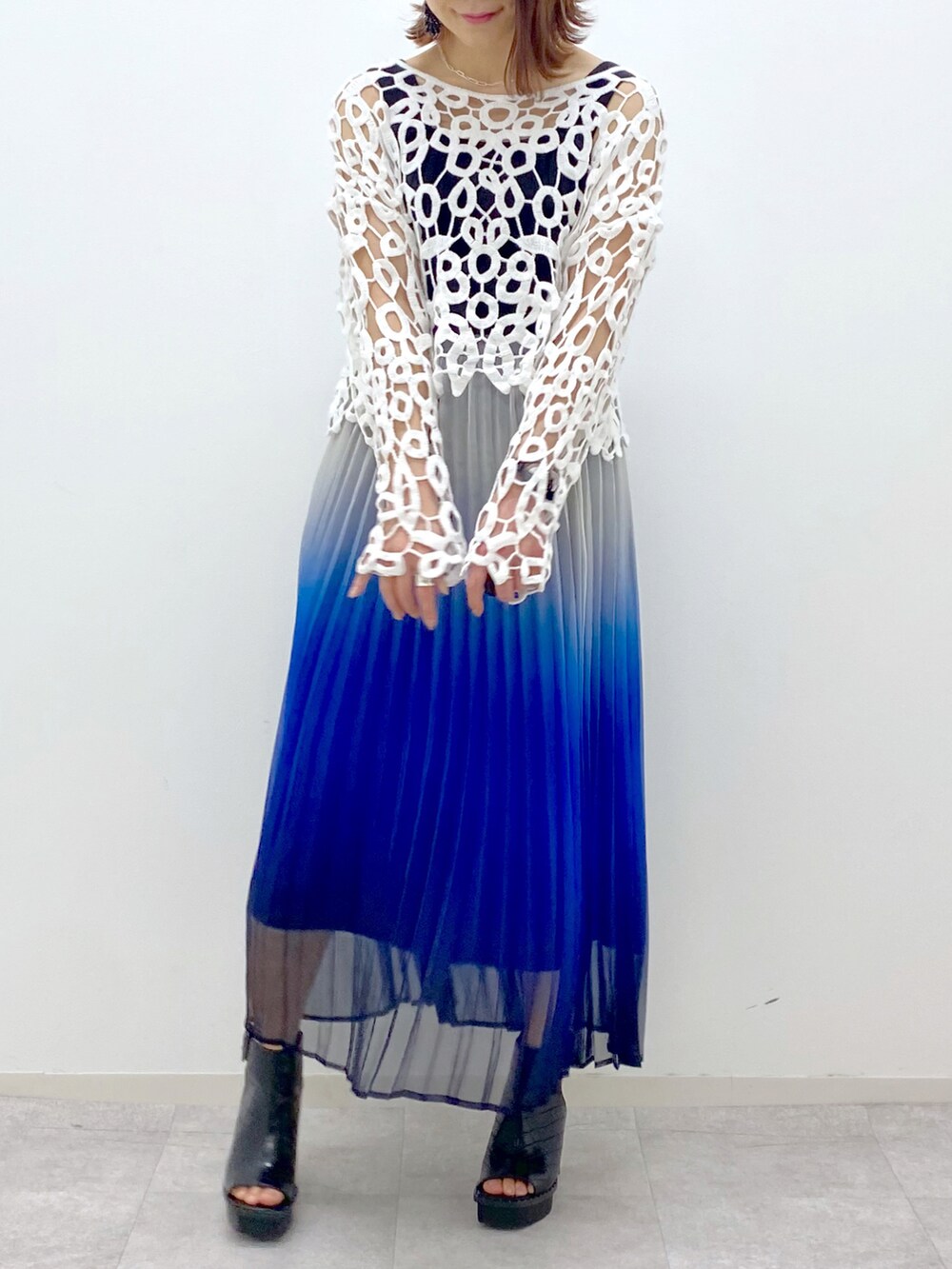 ブルー系のスカート、ブラック系のタンクトップ、ブラック系のサンダルを着用したレディースの春コーディネートの5枚目の写真