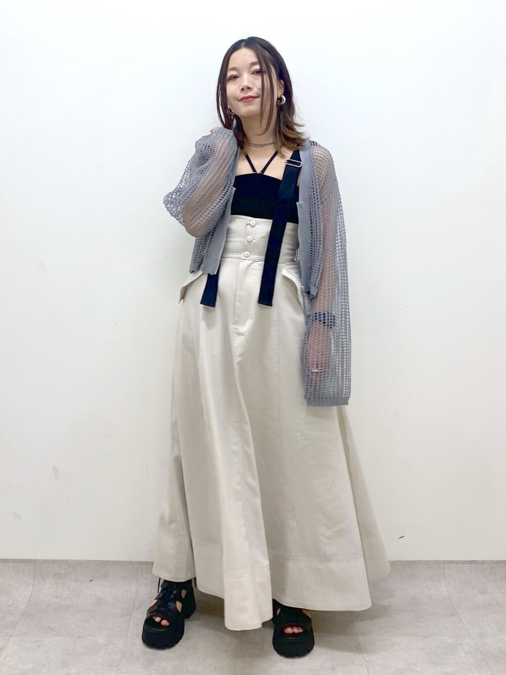 ブラック系のキャミソール、グレー系のカーディガン/ボレロ、ベージュ系のスカートを着用したレディースの春コーディネートの9枚目の写真