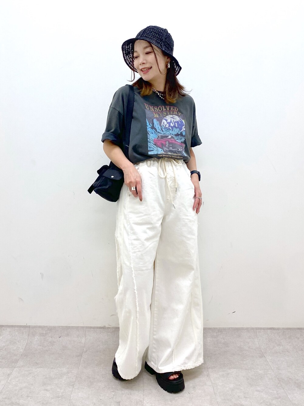 ホワイト系のデニムパンツ、ブラック系のショルダーバッグ、グレー系のTシャツ/カットソーを着用したレディースの春コーディネートの9枚目の写真