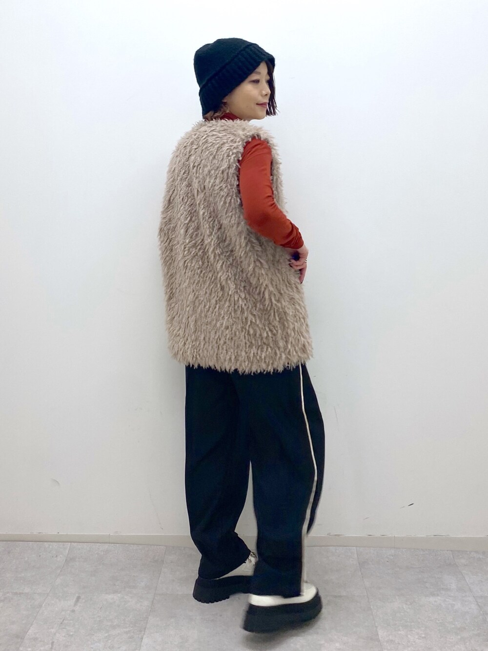 ベージュ系のその他アウター、オレンジ系のTシャツ/カットソー、ホワイト系のシューズを着用したレディースの秋コーディネートの2枚目の写真