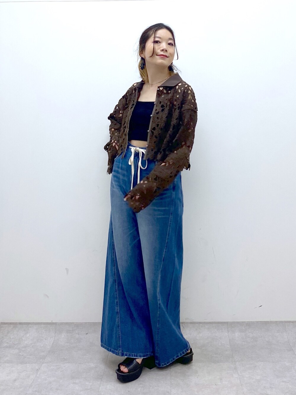 ブルー系のデニムパンツ、ブラウン系のカーディガン/ボレロ、ブラック系のキャミソールを着用したレディースの夏コーディネートの9枚目の写真