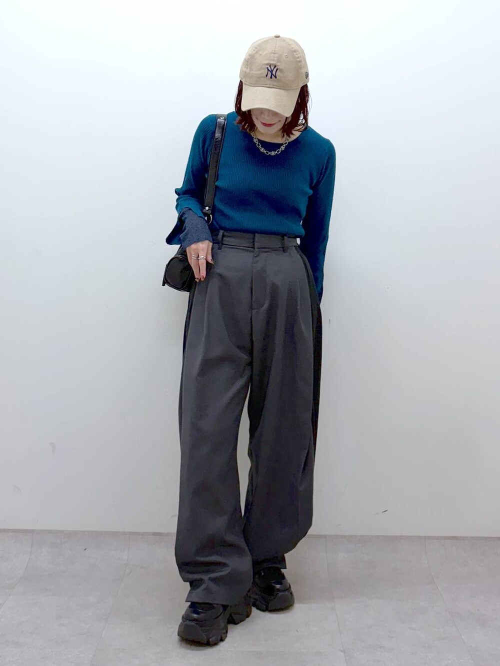 ブラック系のブーツ、グリーン系のニット/セーター、ブラック系のショルダーバッグを着用したレディースの冬コーディネートの8枚目の写真