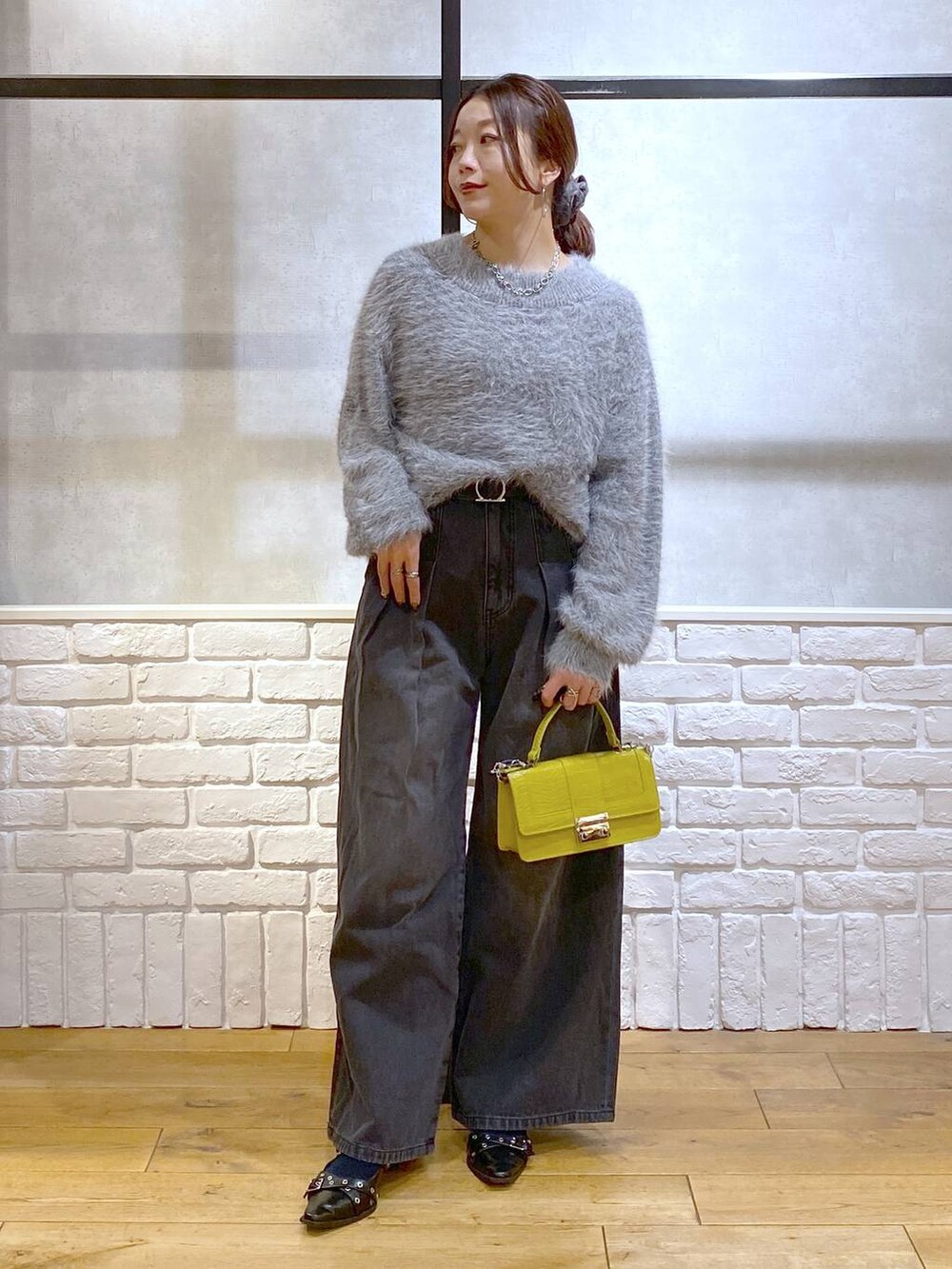 ブラック系のデニムパンツ、イエロー系のハンドバッグ、ブラック系のパンプスを着用したレディースの秋コーディネートの8枚目の写真