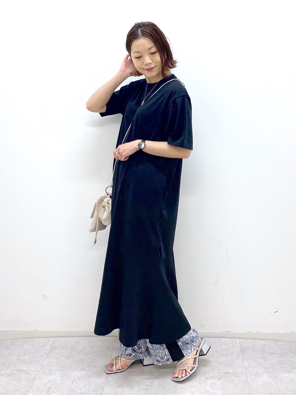 ブラック系のワンピース、ベージュ系のショルダーバッグ、シルバー系のサンダルを着用したレディースの夏コーディネートの3枚目の写真