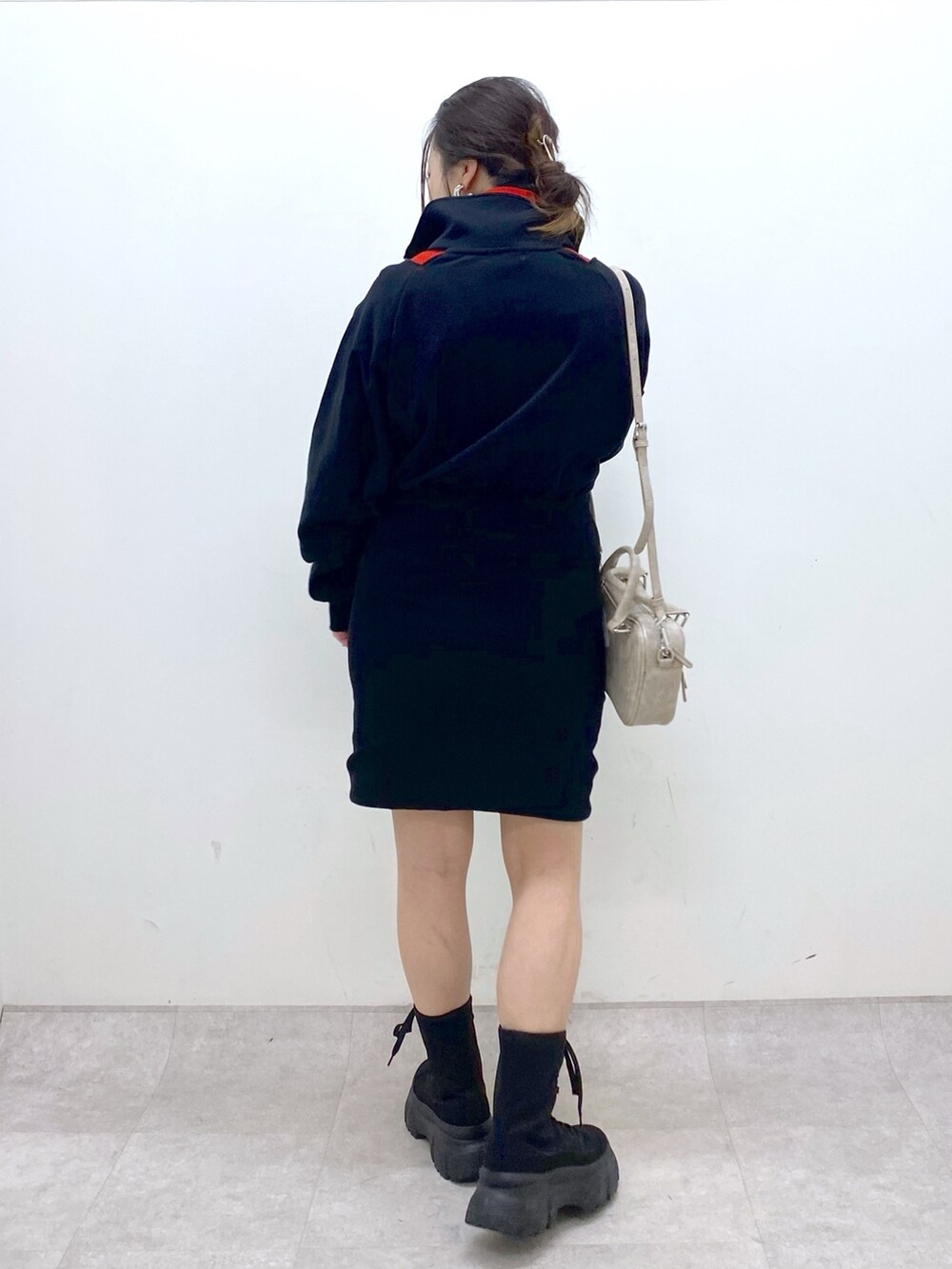 ブラック系のワンピース、レッド系のニット/セーター、ベージュ系のボストンバッグを着用したレディースの冬コーディネートの4枚目の写真