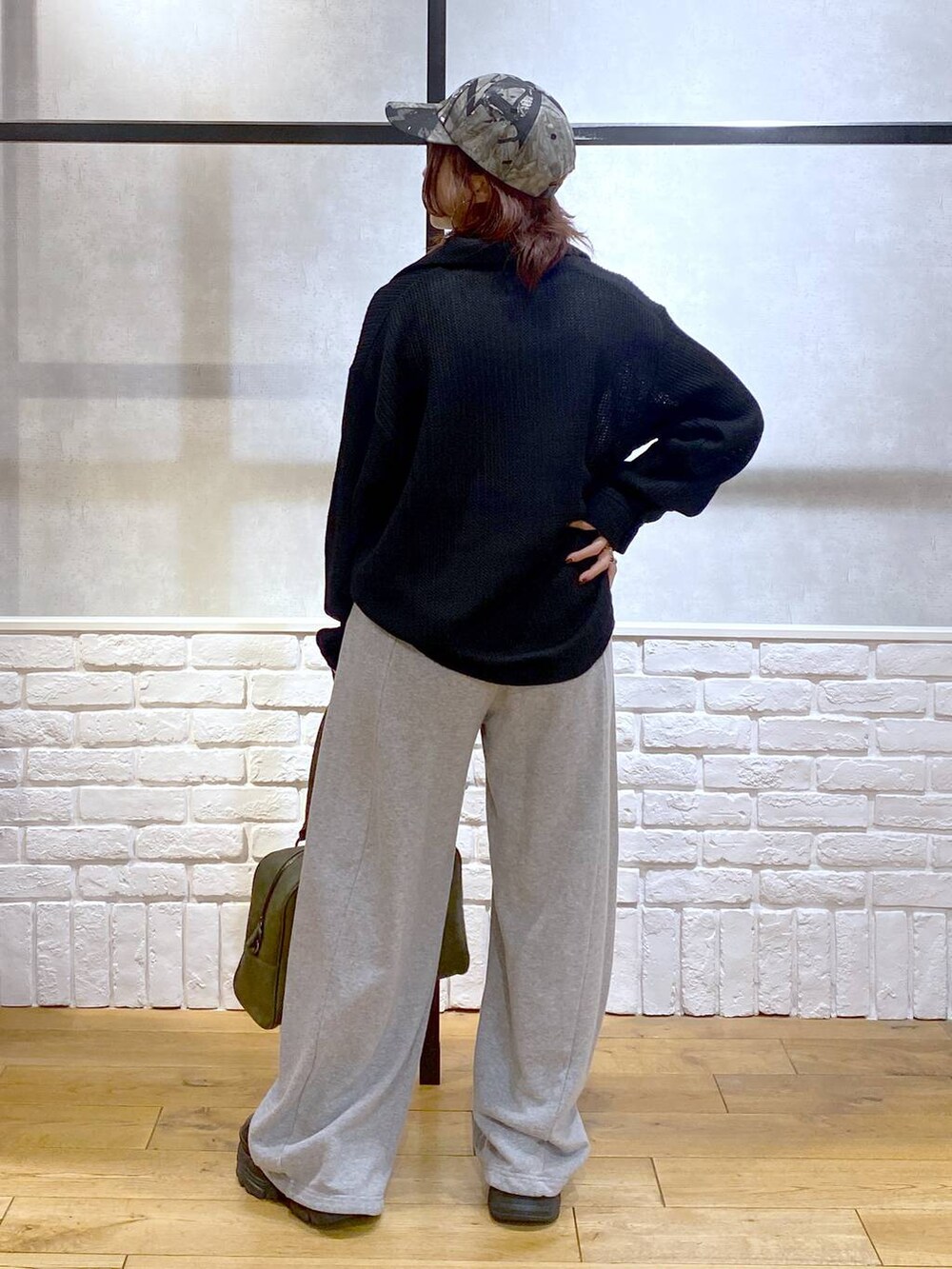 ブラック系のスニーカー、グリーン系のボストンバッグ、グレー系のスウェットパンツを着用したレディースの秋コーディネートの6枚目の写真