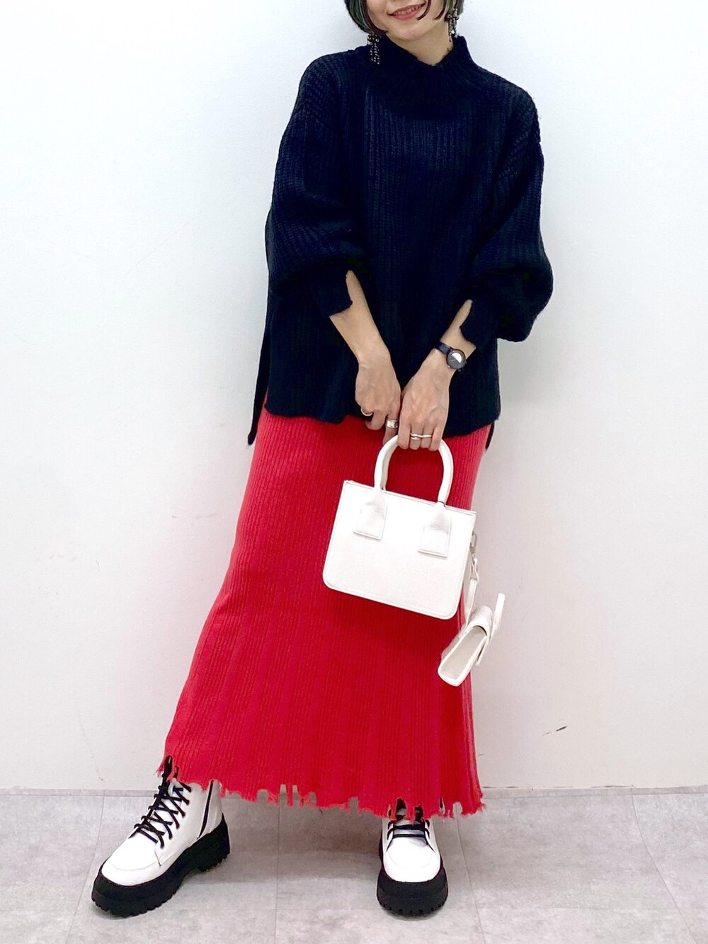 ブラック系のトップス、ゴールド系のスカート、ホワイト系のバッグを着用したレディースの秋コーディネートの5枚目の写真